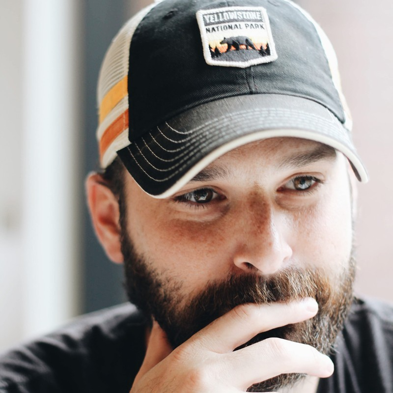 Photo of me wearing a Yellowstone National Park baseball cap. I have dark hair and a beard.